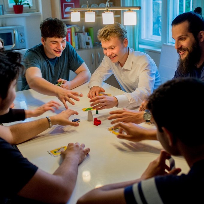 Jugendliche spielen in einer Einrichtung der Jugendhilfe Karten.