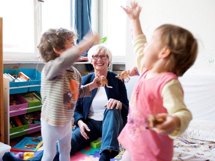 Eine ältere Frau betreut zwei Kinder