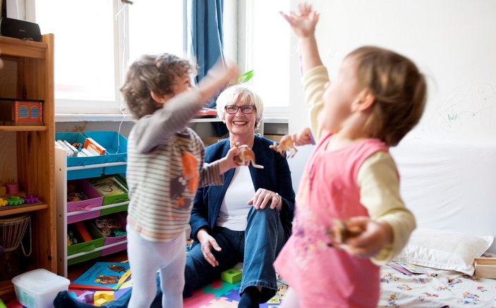 Eine ältere Frau betreut zwei Kinder